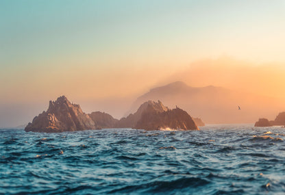 Island in the middle of the ocean with a sunset sky