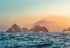 Island in the middle of the ocean with a sunset sky