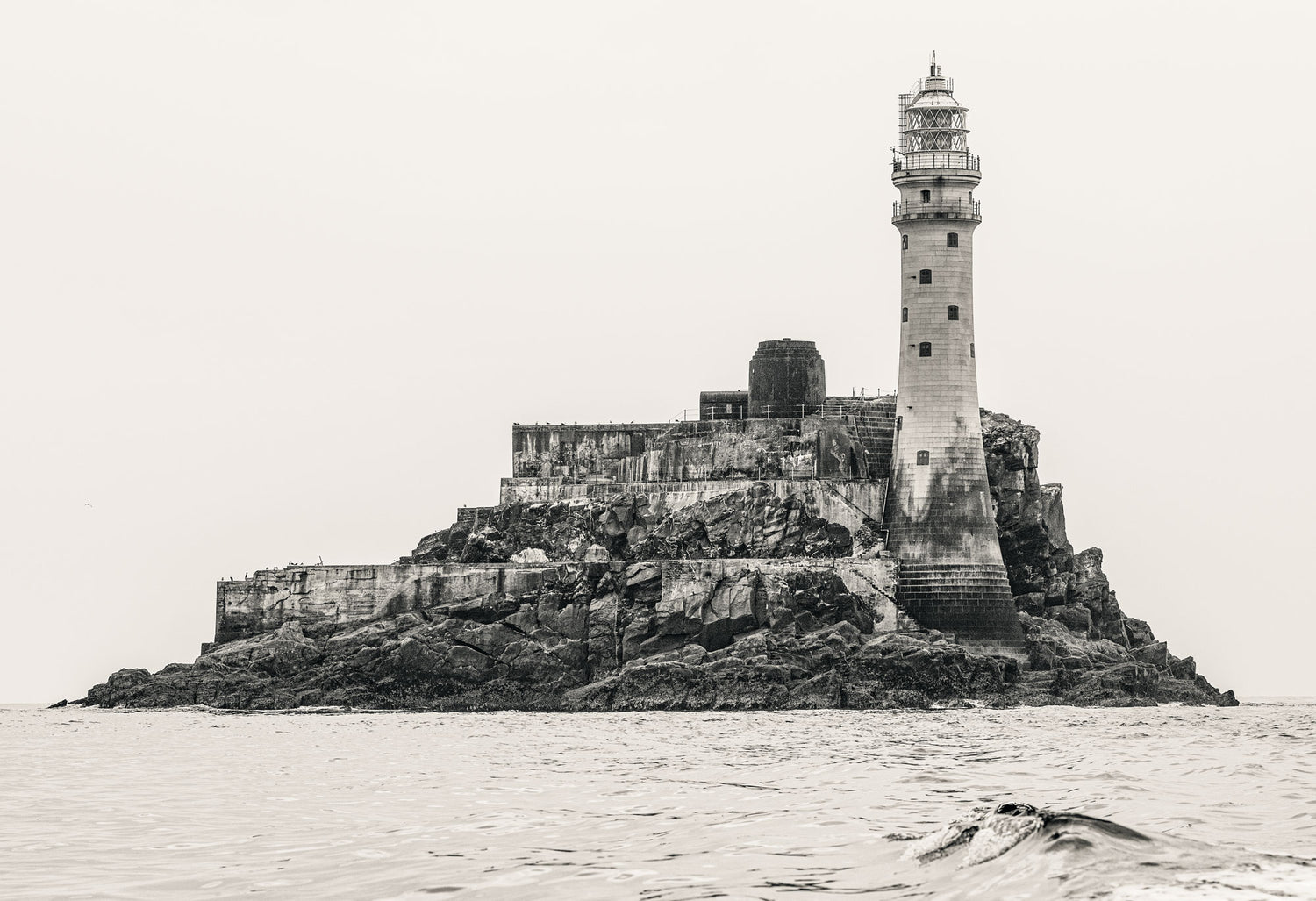 Lighthouse on an island with a fortification in the background