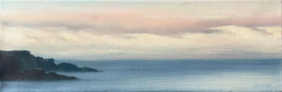 Panoramic view of a coastal landscape with cliffs and misty sea.